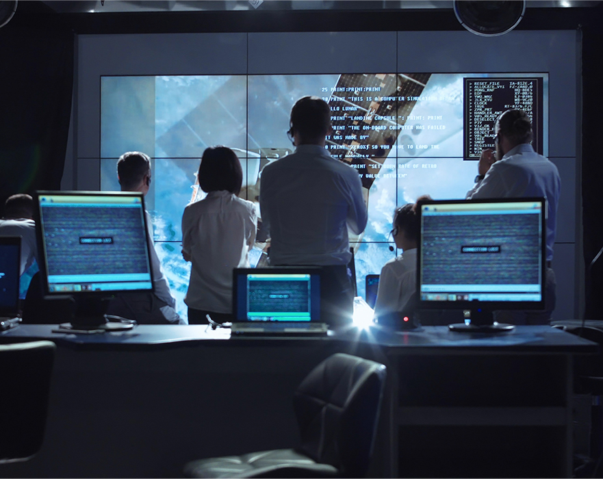 Group of professionals viewing a projection screens for a test readiness review